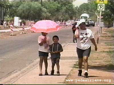 Photo - Pedestrians walking in hot sun.