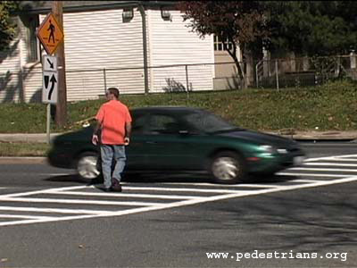 Car speeding past a decoy pedestrian in a crosswalk.