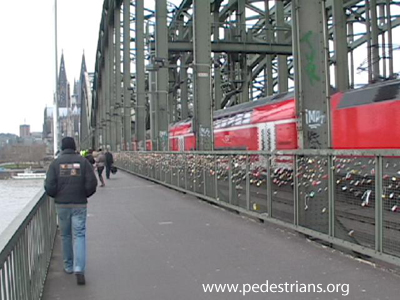 pedestrians on wide path on railroad bridge in Germany.